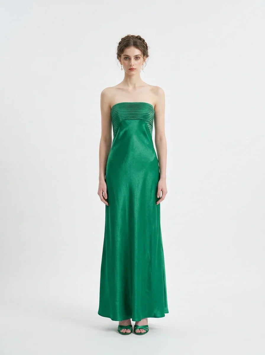 Woman standing in a green strapless satin gown with a pleated bodice, front view