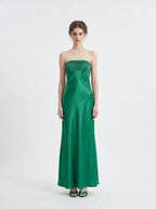 Woman standing in a green strapless satin gown with a pleated bodice, front view