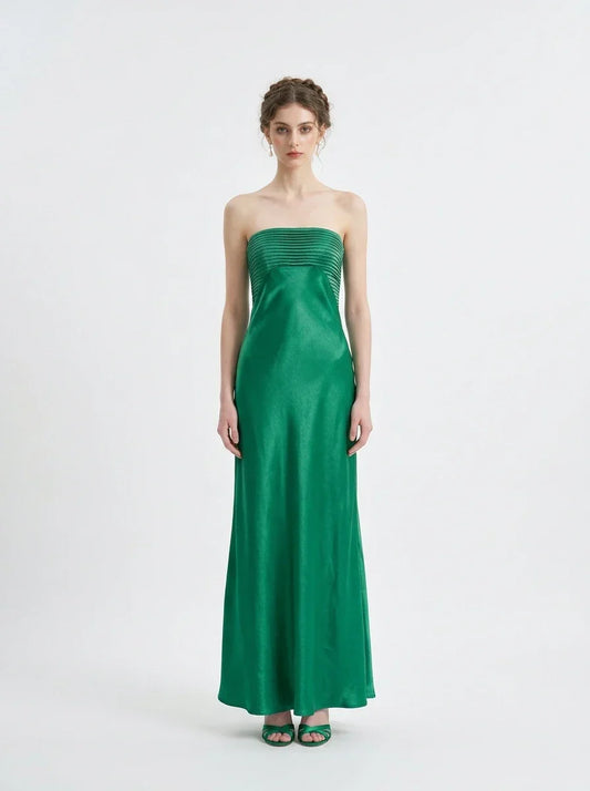 Woman standing in a green strapless satin gown with a pleated bodice, front view