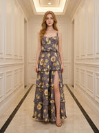 Woman standing in a hallway wearing a floral print maxi dress with a high slit