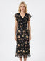 Woman wearing a black floral print midi dress with a v-neckline and short ruffled sleeves.