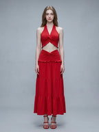 Woman wearing a red halter crop top and a tiered maxi skirt, front view