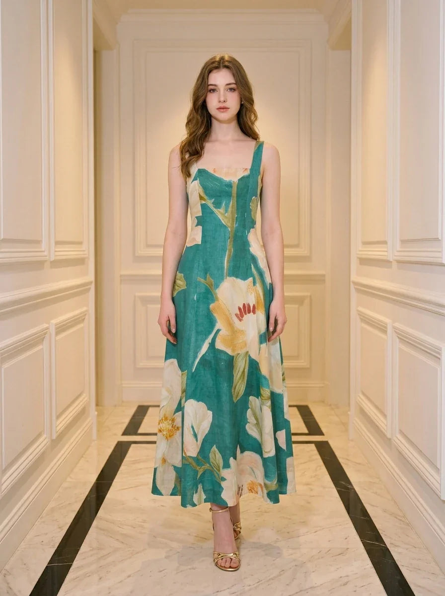 Woman standing in a hallway wearing a teal floral print midi dress