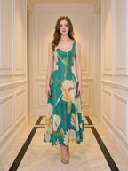 Woman standing in a hallway wearing a teal floral print midi dress