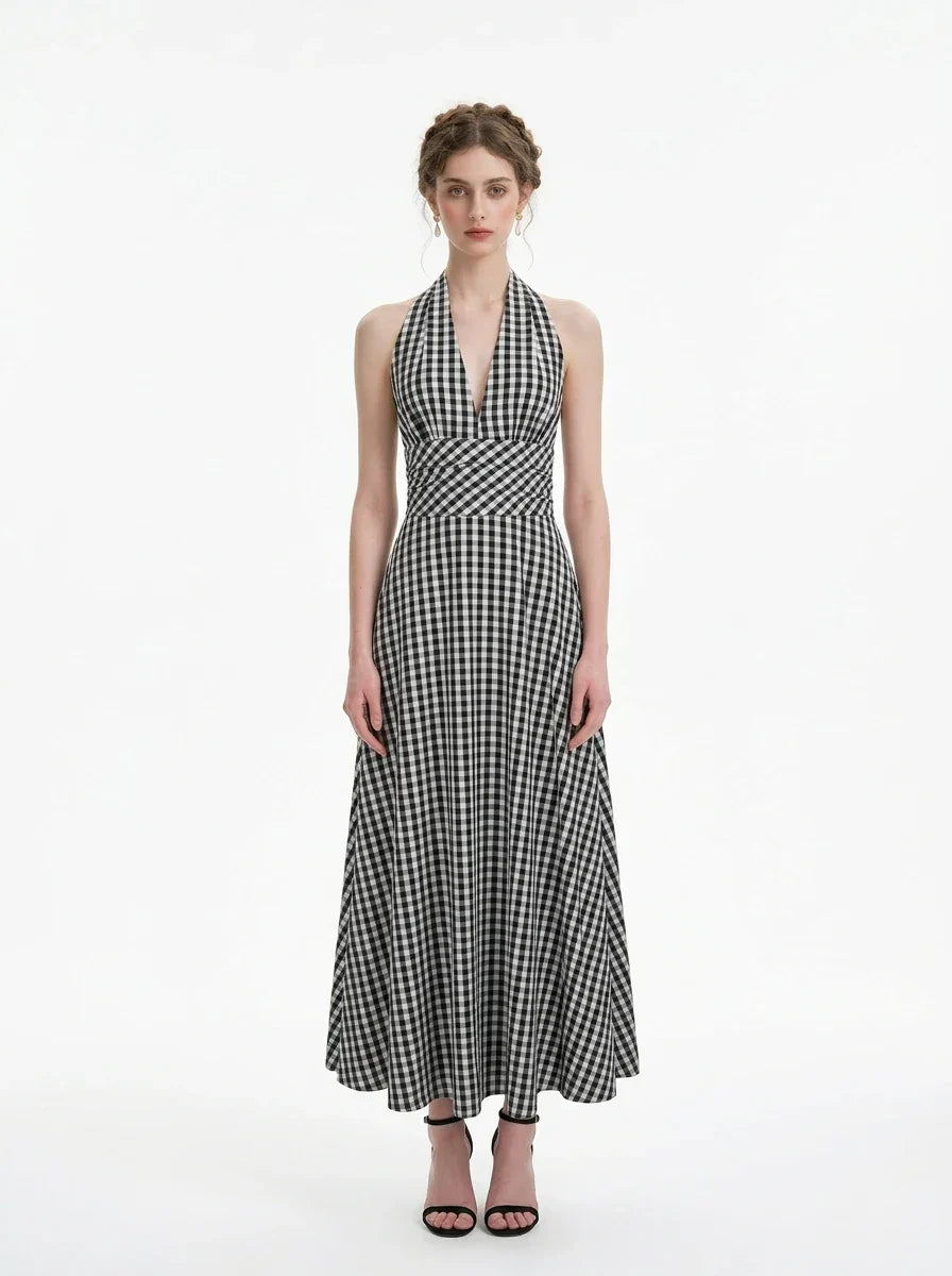 Woman wearing a black and white gingham halter maxi dress, front view
