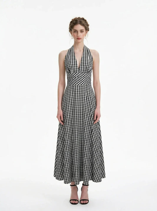 Woman wearing a black and white gingham halter maxi dress, front view
