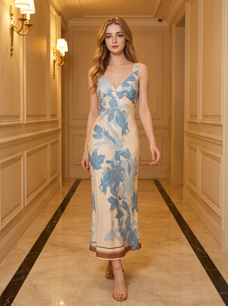Woman wearing a cream and blue floral print satin midi dress, standing in a hallway.