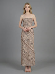 Woman wearing a strapless, patterned maxi dress standing against a grey background, front view.