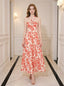 Woman wearing a cream and coral floral print halter midi dress, standing in a hallway.