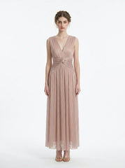 Woman in a rose gold shimmering metallic A-line V-neck sleeveless floor-length formal gown, front view