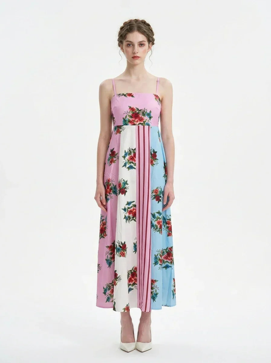 woman in a pink, blue, and white floral print maxi dress with spaghetti straps, standing against a white background