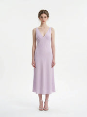Model wearing a lavender midi dress with a V-neckline and sleeveless design, standing against a white background.
