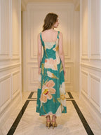 Back view of a woman in a teal floral print midi dress