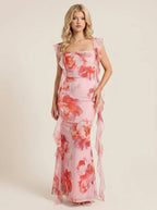 Woman wearing a pink floral print maxi dress with ruffle trim