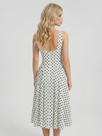Back view of a woman in a white polka dot dress