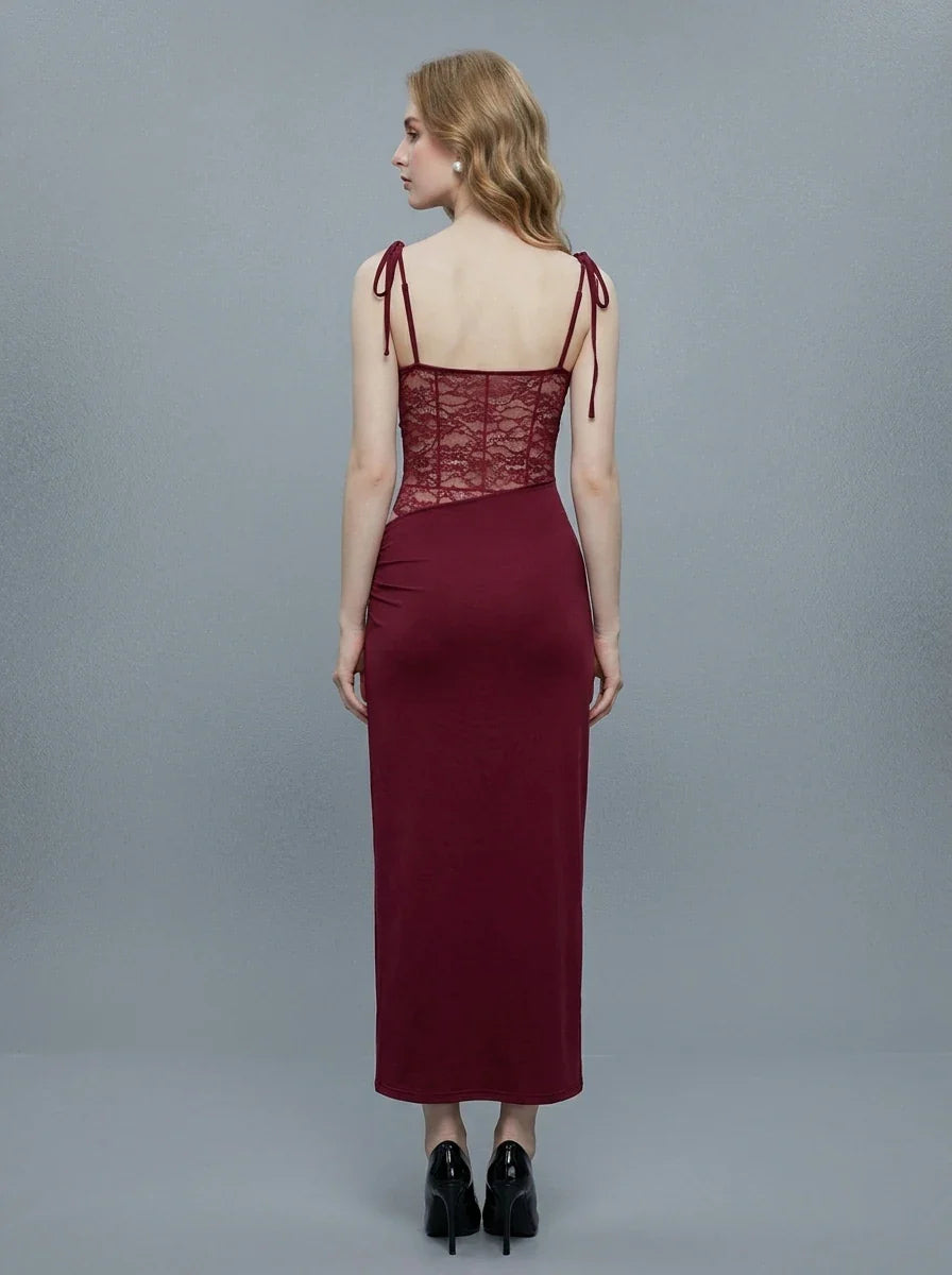 Back view of a woman in a burgundy slip dress with lace detailing on the bodice and sides.