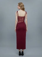 Back view of a woman in a burgundy slip dress with lace detailing on the bodice and sides.