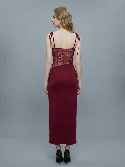 Back view of a woman in a burgundy slip dress with lace detailing on the bodice and sides.