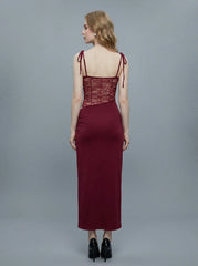 Back view of a woman in a burgundy slip dress with lace detailing on the bodice and sides.