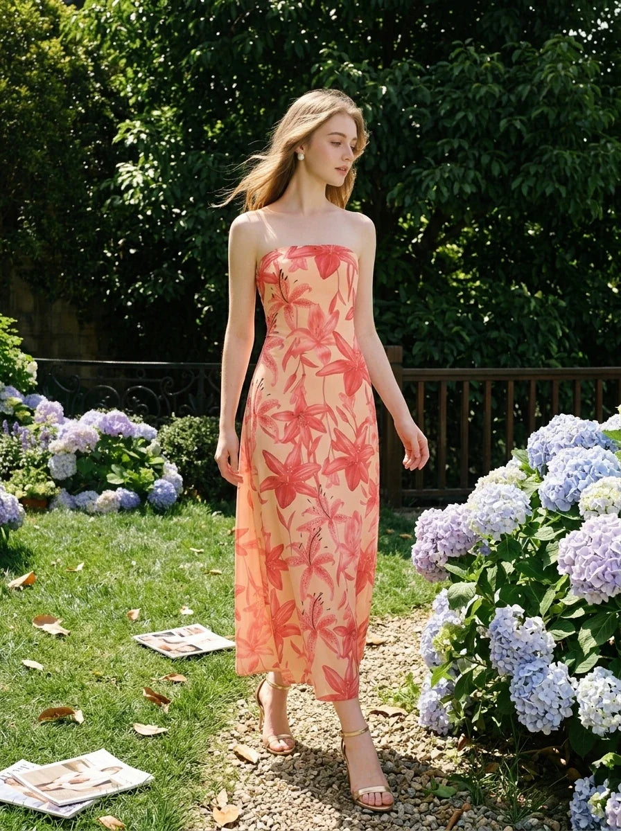 Woman walking through a garden with hydrangeas, wearing a strapless floral print midi dress.