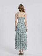Back view of a woman in a light blue floral print midi dress.