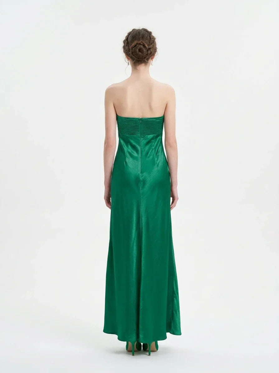 Woman standing in a green strapless satin gown with a pleated bodice, back view