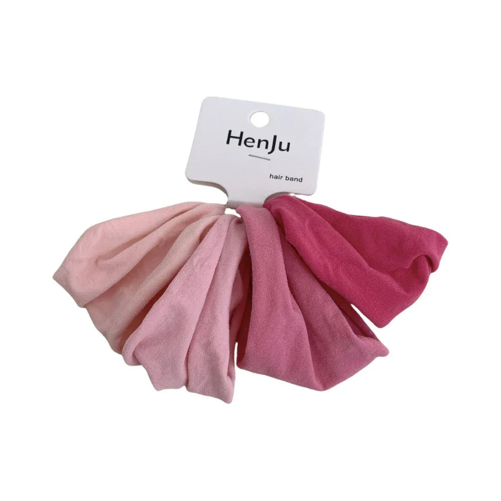A set of pink scrunchies with a white tag that says 'HenJu hair band'.
