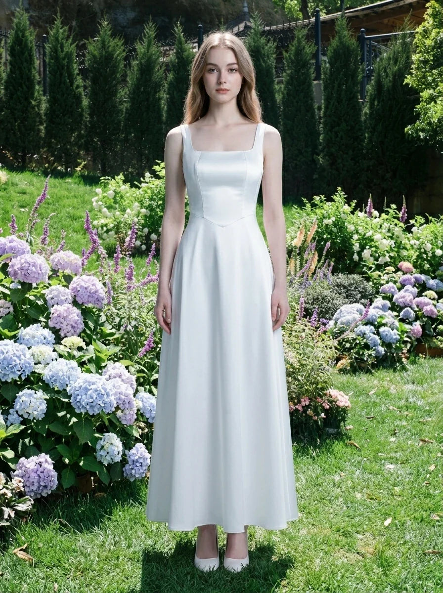Woman wearing a white satin sleeveless A-line wedding dress with a square neckline, standing in a garden with hydrangeas