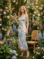 Woman wearing a cream and blue floral print satin midi dress, posing in a garden with roses.