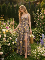 Woman in a garden wearing a floral print maxi dress with a high slit, surrounded by flowers