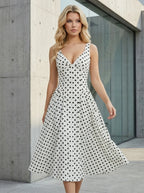 Woman in a white polka dot dress with her hand outstretched