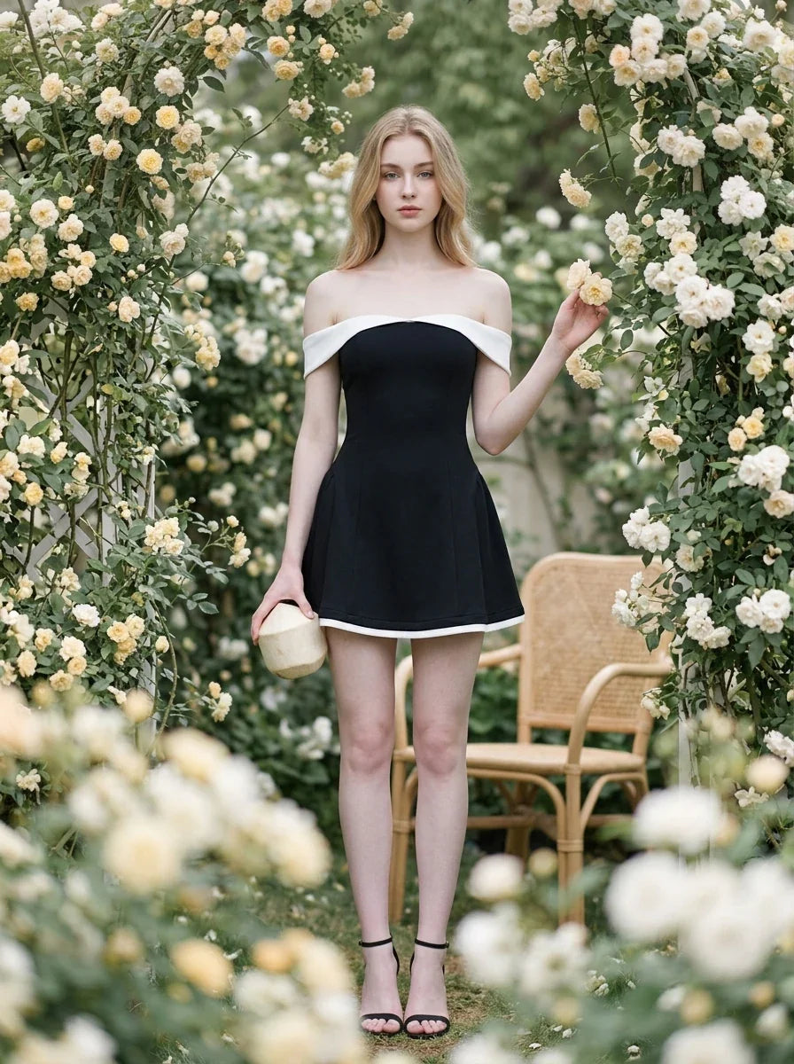 woman in black and white off-the-shoulder dress holding round object in rose garden