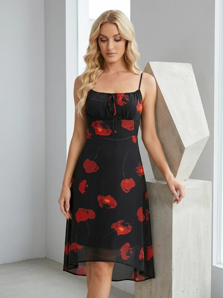 Woman posing in a black floral print midi dress indoors.