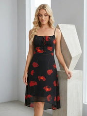 Woman posing in a black floral print midi dress indoors.