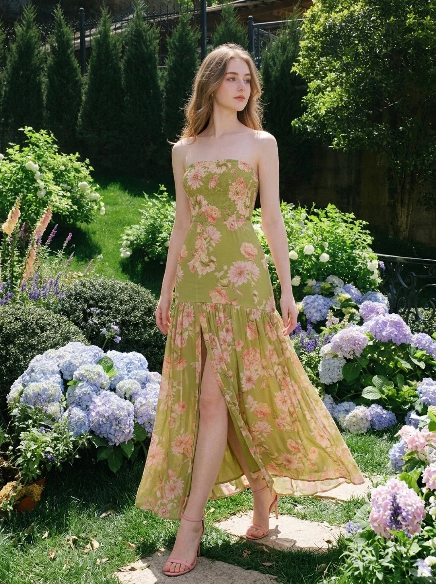 woman in a green floral strapless maxi dress with a high slit standing in a garden with hydrangeas