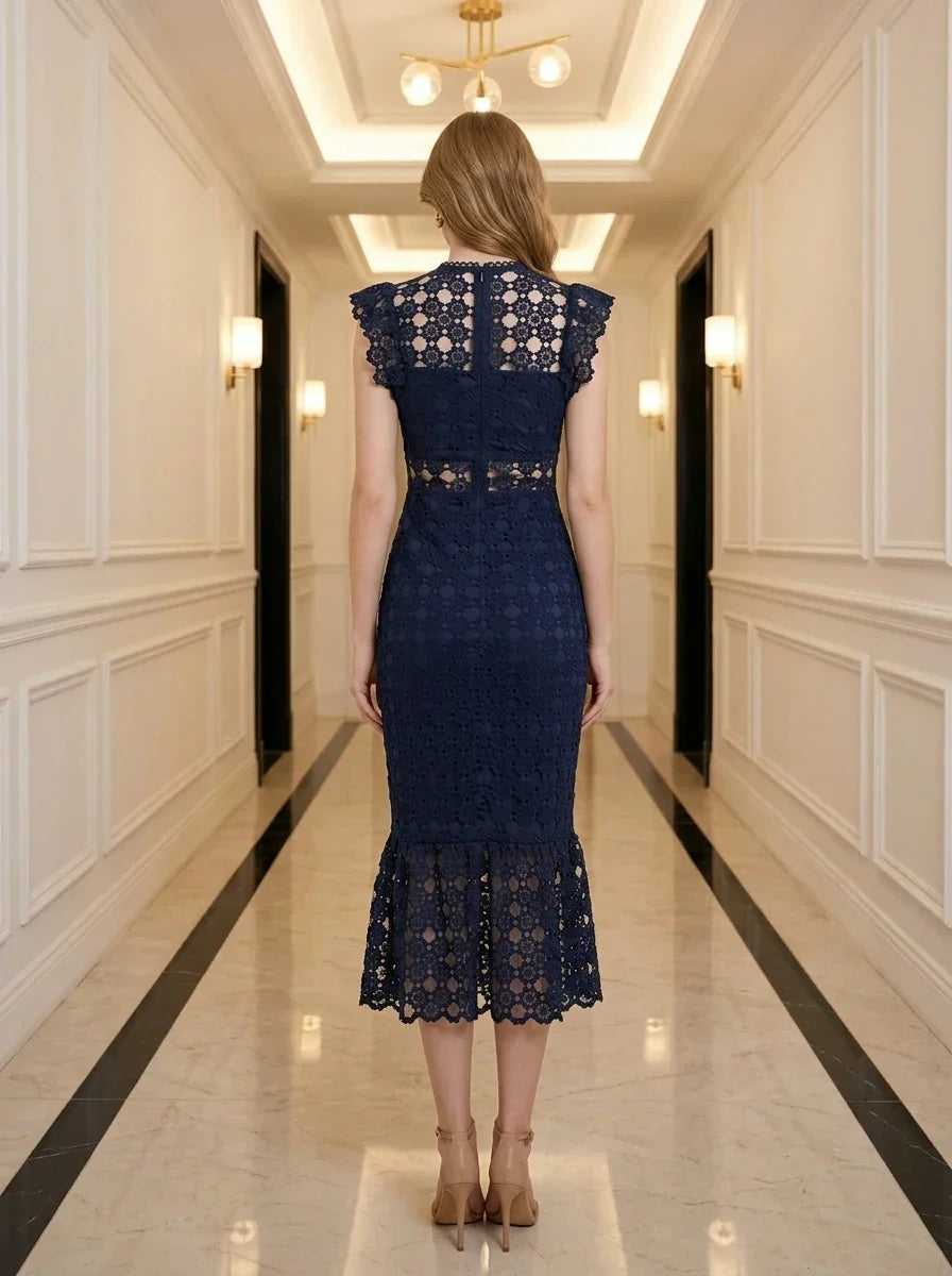 Back view of a woman in a navy blue lace mermaid dress with a high neck and cap sleeves.