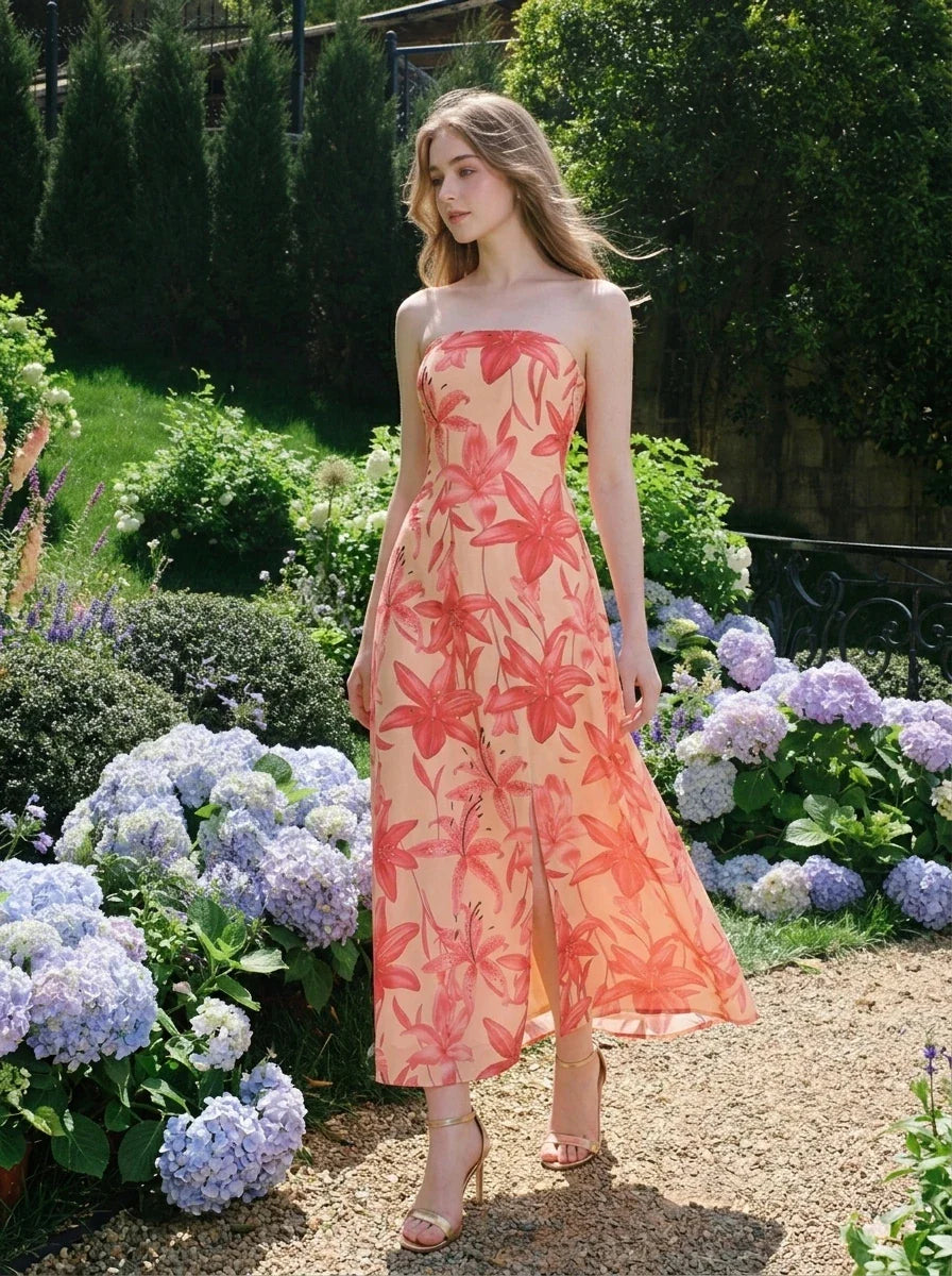 Woman walking in a garden wearing a strapless floral print midi dress with a side slit.