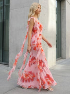 Woman walking in a pink floral print maxi dress with ruffle trim outdoors