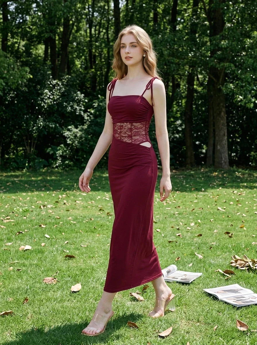 Woman walking in a park wearing a burgundy slip dress with lace waist detailing.