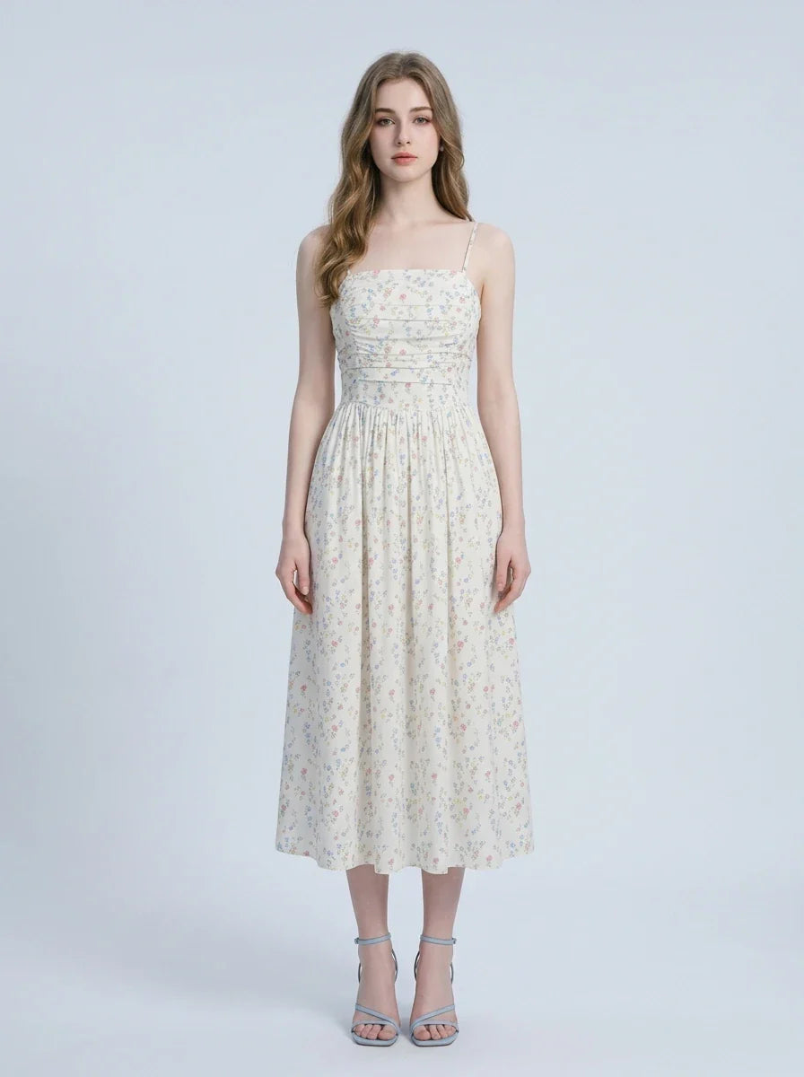 Woman wearing a white floral print midi dress with spaghetti straps and a square neckline, standing against a white background.
