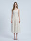 Woman wearing a white floral print midi dress with spaghetti straps and a square neckline, standing against a white background.