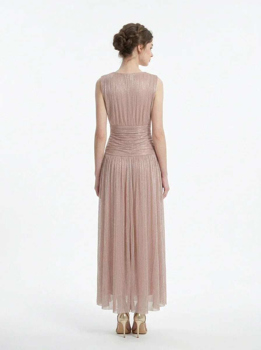 Woman in a rose gold shimmering metallic A-line V-neck sleeveless floor-length formal gown, back view