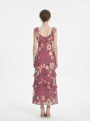 Woman wearing a pink floral print maxi dress with ruffle trim, back view