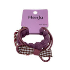 Close-up of a lavender hair tie with a brown and white plaid bow.
