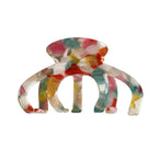 A single multi-colored acetate claw hair clip with an octopus-like design, featuring interlocking teeth and a marbled pattern of pink, red, yellow, green, and white.