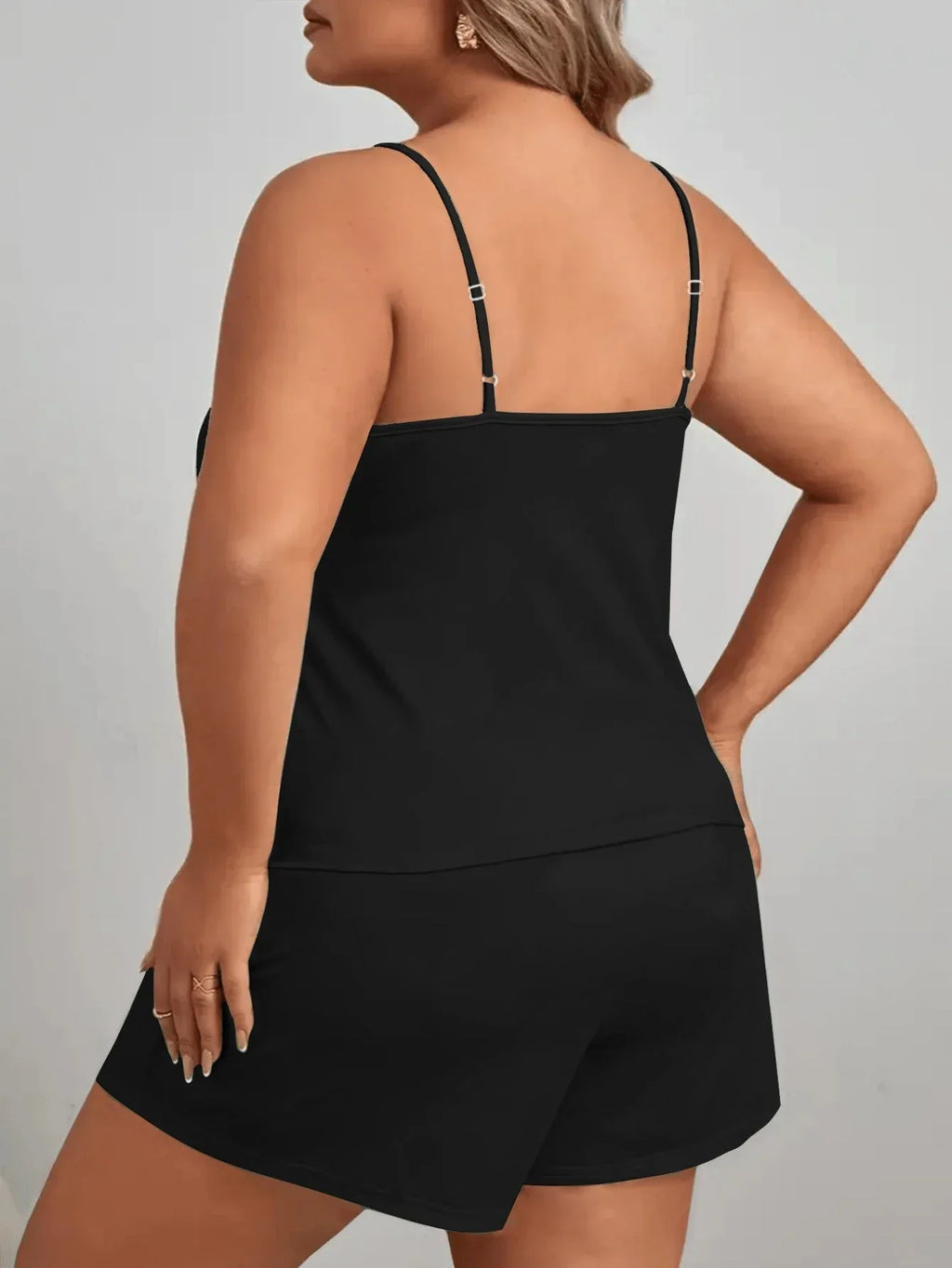 Back view of a woman in a black pajama set with adjustable straps.