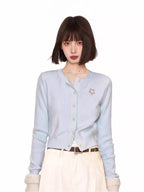 Light blue knit cardigan with embroidered detail and button-up closure