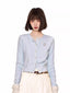 Light blue knit cardigan with embroidered detail and button-up closure