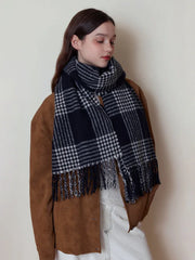 Close-up of a woman wearing a black and white plaid scarf with fringe detail