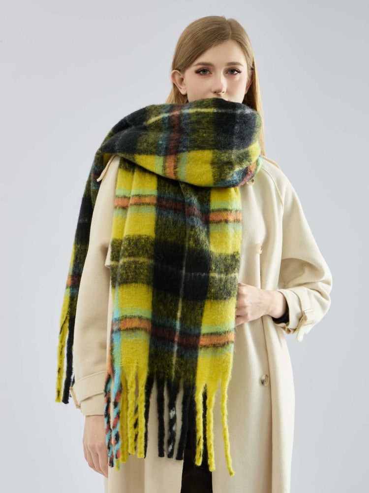 Woman wearing a yellow and black plaid scarf with fringe detail.